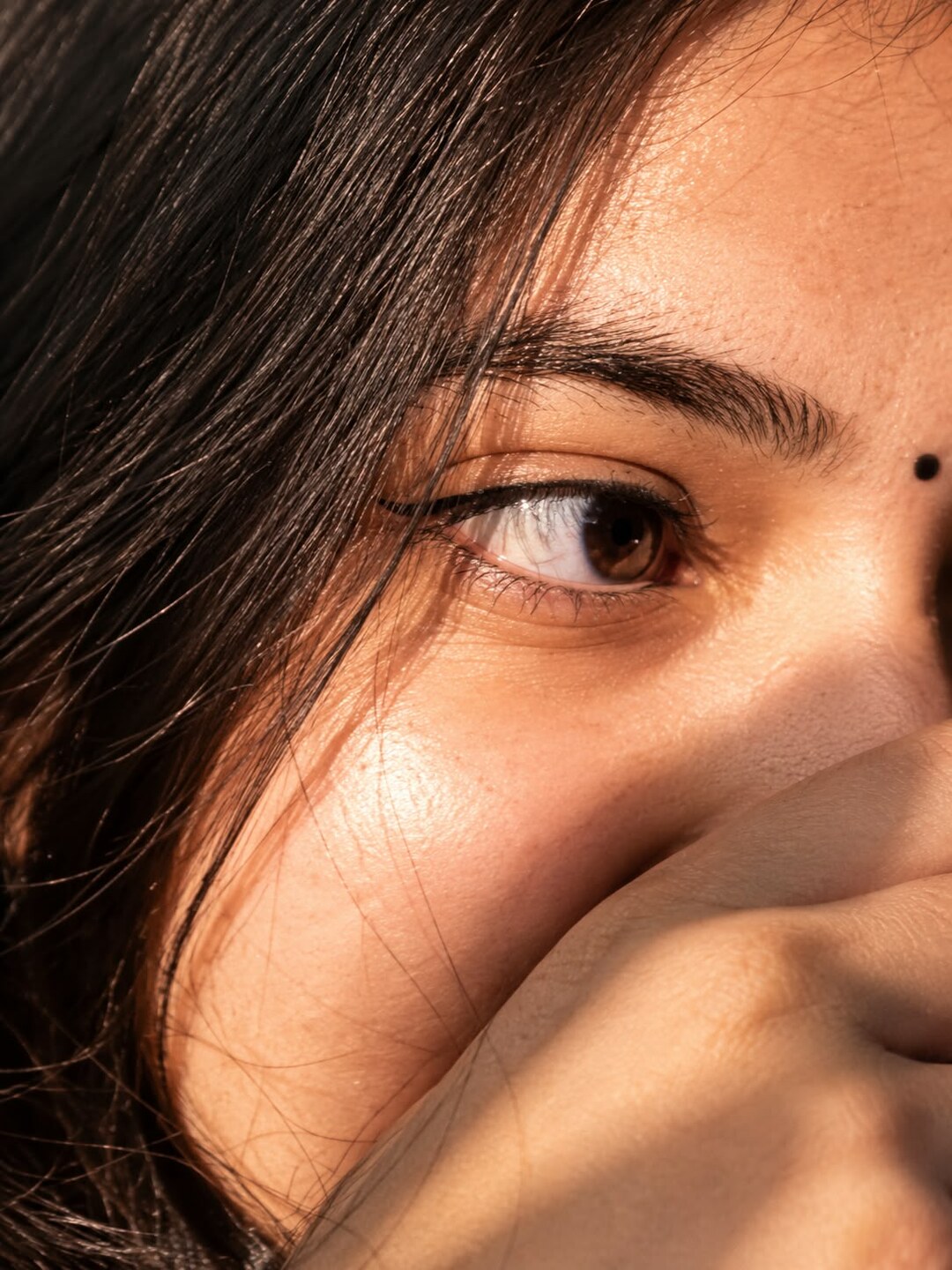 Macro single eye photo prompt result - golden hour close-up with hand covering lower face